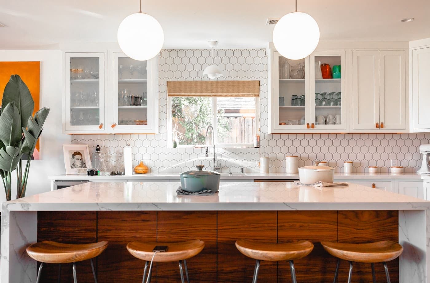 Four brown wooden stools lined up at a clean kitchen island