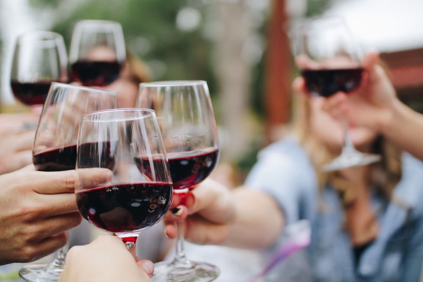 Glasses of red wine on a dark wooden bar in warm low light