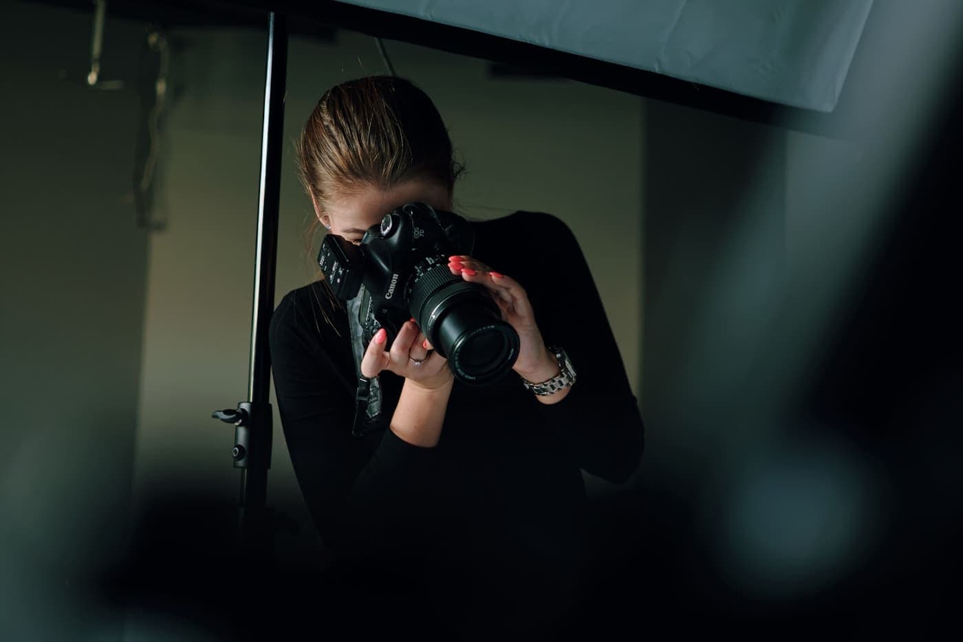 Photographer working in a studio, framing a shot with a camera