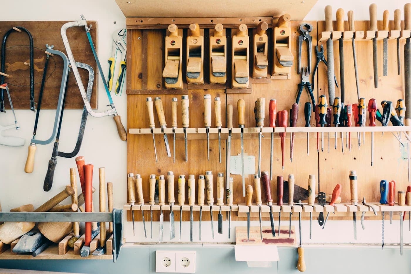 Assorted hand tools neatly arranged in a workshop tool rack