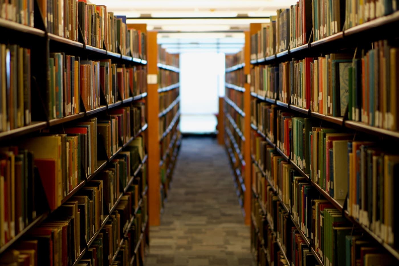 Library aisle lined with tall bookshelves filled with books