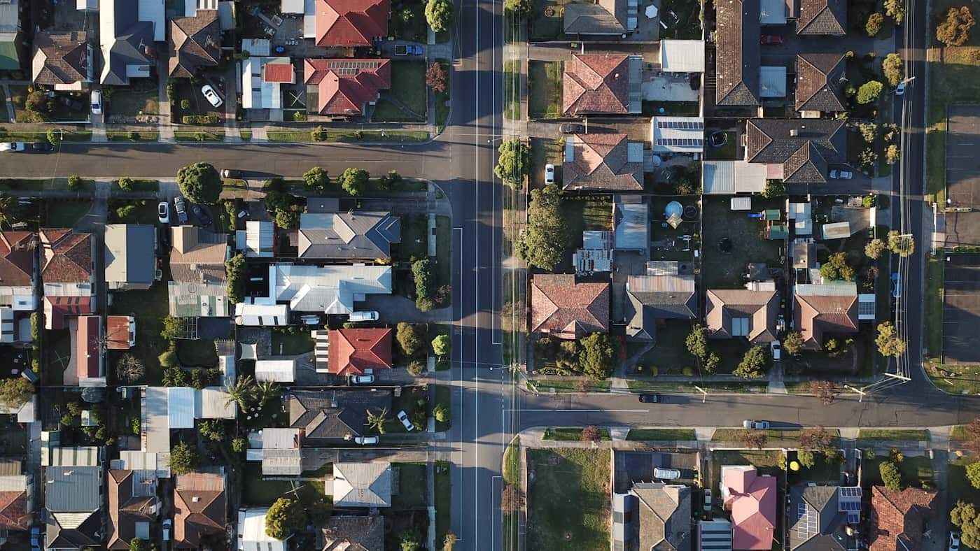 Top-down aerial view of a suburban neighborhood of pitched-roof houses