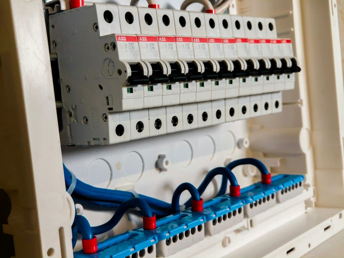 Row of white circuit breakers inside an electrical panel